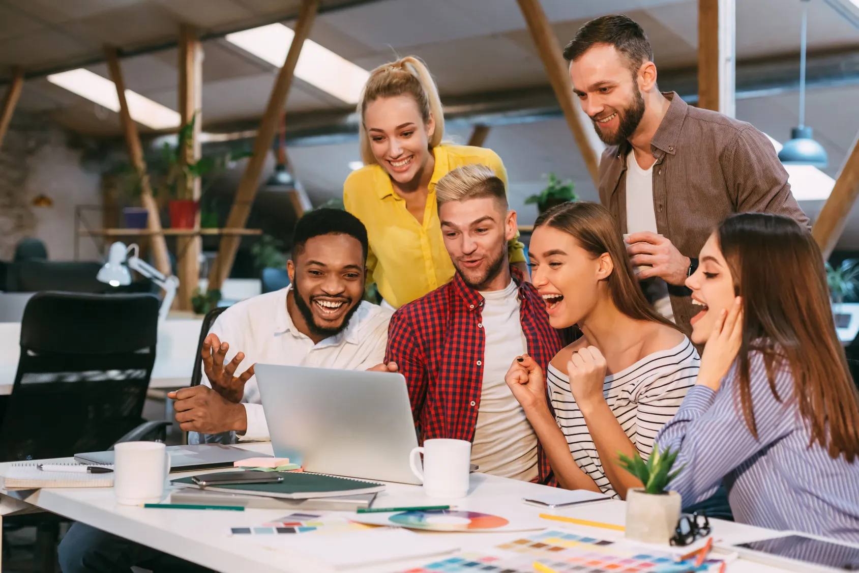 Une équipe de six personnes réunies autour d’une table dans un bureau moderne, échangeant des idées avec un ordinateur portable ouvert, des carnets, une tasse de café et des échantillons de couleurs. L’image reflète l’innovation et la collaboration dynamique au sein de la plateforme business de Madagasy.com